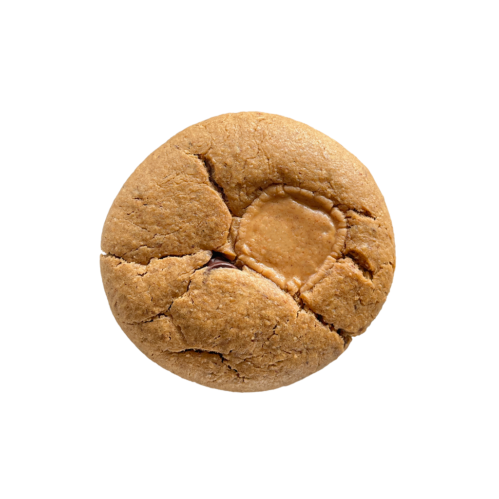 Top-down view of a round, golden-brown cookie with cracks across the surface and a smooth round peanut butter chip pressed into the center.