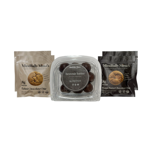Three Mindfully Mina’s products side by side: a pouch of Tahini Chocolate Chip protein cookies on the left, a clear container of brownie batter protein balls in the center, and a pouch of Peanut Butter Chocolate Chip protein cookies on the right. Each package is labeled “8g protein.”