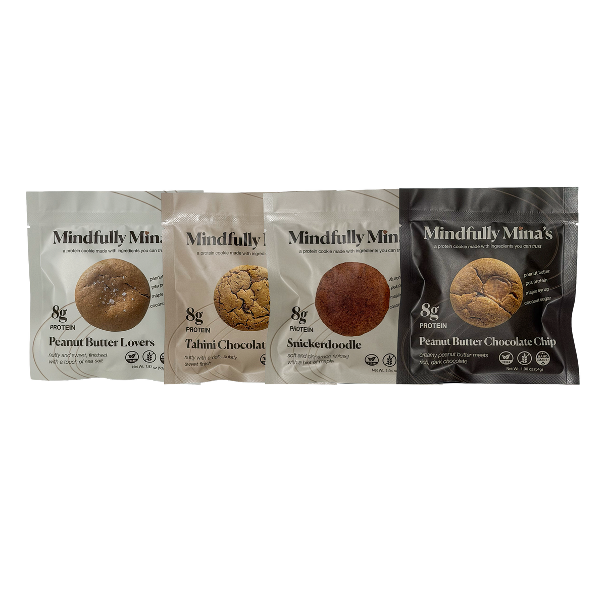 Four Mindfully Mina’s protein cookie pouches side by side, each showing a round cookie in a window and labeled “8g protein.” From left to right: Peanut Butter Lovers in a white pouch, Tahini Chocolate Chip in a beige pouch, Snickerdoodle in a cream pouch, and Peanut Butter Chocolate Chip in a brown pouch.