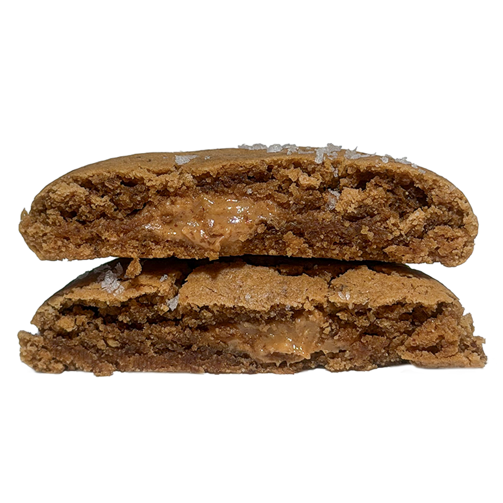 A cookie cut in half and stacked, showing a soft brown interior with a melty peanut butter center and flakes of sea salt on the crust.