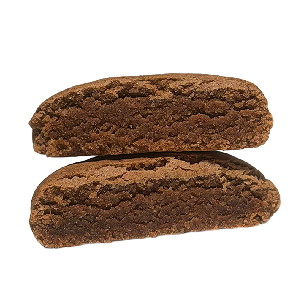 A Snickerdoodle protein cookie cut in half and stacked, showing a dense, soft, dark brown interior with a lighter, crackled crust.