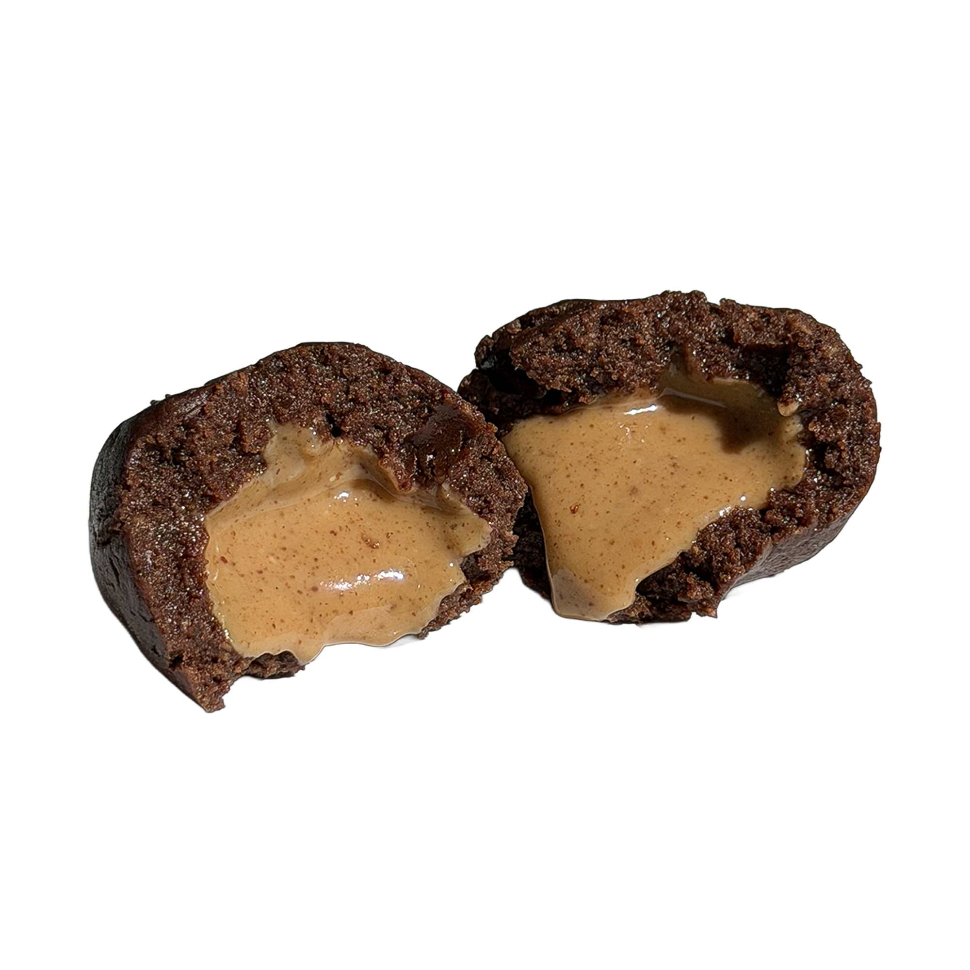 Close-up of a dark chocolate protein ball cut in half, with a smooth, glossy peanut butter center spilling out of the fudgy interior.
