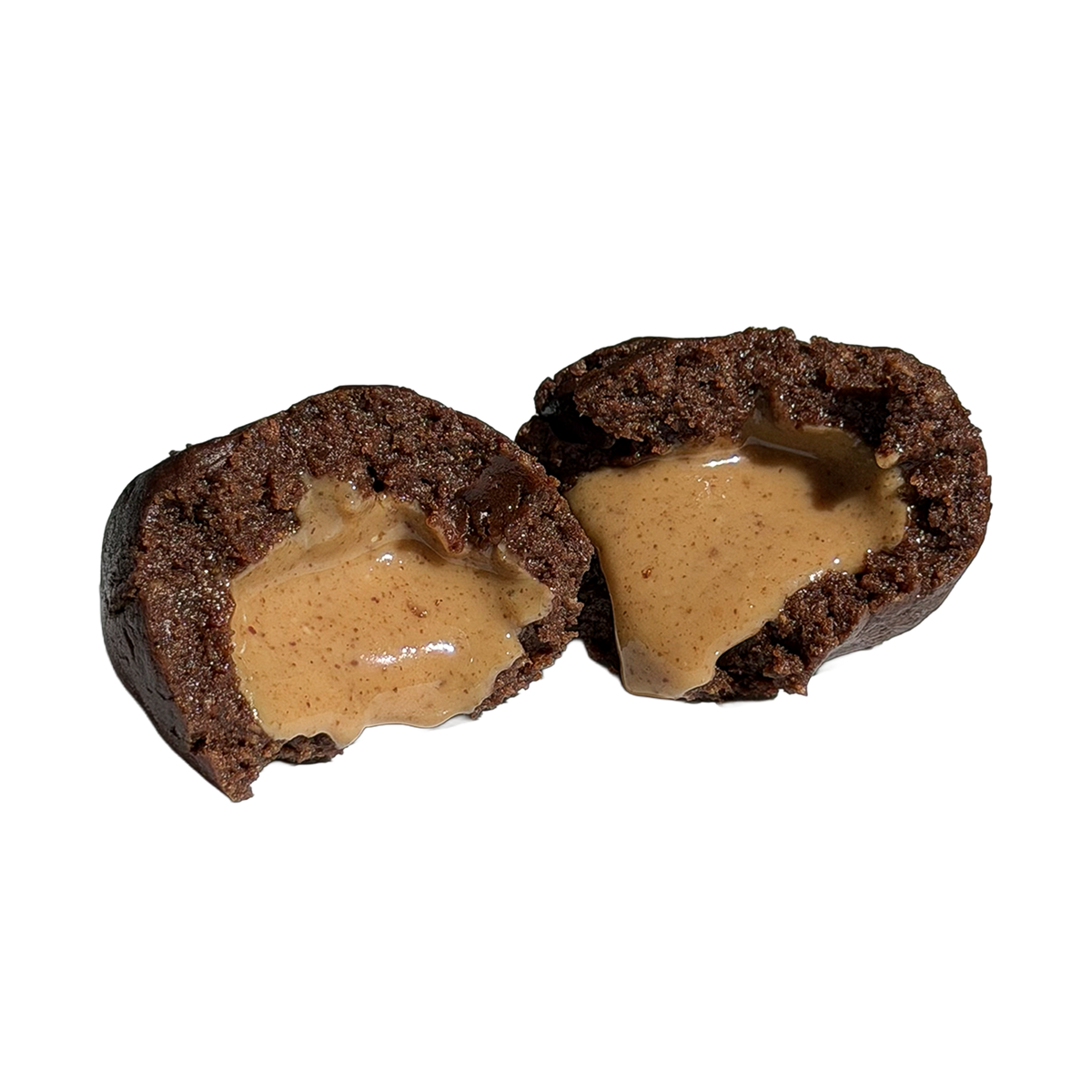 Close-up of a dark chocolate protein ball cut in half, with a smooth, glossy peanut butter center spilling out of the fudgy interior.